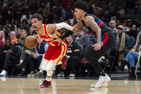 Atlanta Hawks guard Trae Young drives against Detroit Pistons guard Killian Hayes during the first half of an NBA basketball game Friday, Dec. 23, 2022, in Atlanta. (AP Photo/Hakim Wright Sr.)