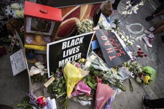Items are left in honor George Floyd during a protest Tuesday, May 26, 2020, in Minneapolis. Four Minneapolis officers involved in the arrest of Floyd, a black man who died in police custody, were fired Tuesday, hours after a bystander’s video showed an officer kneeling on the handcuffed man’s neck, even after he pleaded that he could not breathe and stopped moving. (Richard Tsong-Taatarii/Star Tribune via AP)