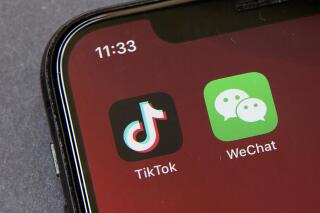 FILE - Icons for the smartphone apps TikTok and WeChat are seen on a smartphone screen in Beijing, in a Friday, Aug. 7, 2020 file photo.  Officials say the White House has dropped Trump-era executive orders that attempted to ban the popular apps TikTok and WeChat and will conduct its own review aimed at identifying national security risks with software applications tied to China. A new executive order directs the Commerce Department to undertake what officials describe as an “evidence-based” analysis of transactions involving apps that are manufactured or supplied or controlled by China. Officials are particularly concerned about apps that collect users’ personal data or have connections to Chinese military or intelligence activities. (AP Photo/Mark Schiefelbein, File)