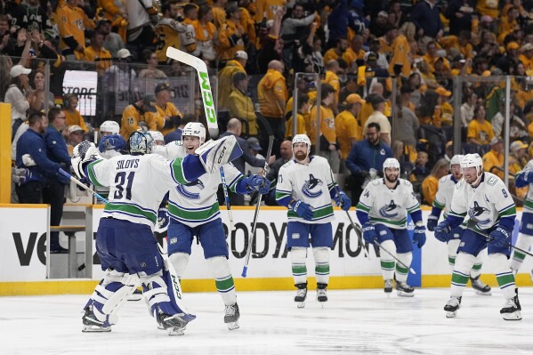 Vancouver Canucks goaltender Arturs Silovs (31) and defenseman Carson Soucy (7) celebrate the team's 4-3 overtime win against the Nashville Predators in Game 4 of an NHL hockey Stanley Cup first-round playoff series Sunday, April 28, 2024, in Nashville, Tenn. (AP Photo/George Walker IV)