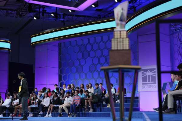 With the trophy in the foreground, Faizan Zaki, 13, of Dallas, competes in the finals of the Scripps National Spelling Bee, Thursday, May 29, 2025, in Oxon Hill, Md. (AP Photo/Julia Demaree Nikhinson)