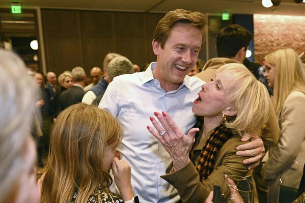 FILE - Mike Johnston, a Denver mayoral candidate, hugs Cheryl Holt and supporters in Denver, April 4, 2023. Denver will choose its next mayor Tuesday, June 6, 2023, in a runoff election between two moderate candidates — Kelly Brough, the former president and CEO of the Denver Metro Chamber of Commerce, and Johnston, a former state senator — seeking to lead a rapidly growing city faced with out-of-control housing costs and increased homelessness. Johnston and Brough were the top two vote-getters in a 16-way race in April, sending the race to Tuesday's runoff. (Hyoung Chang/The Denver Post via AP, File)