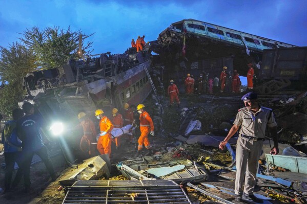 Rescuers carry the body of a victim at the site of passenger trains that derailed in Balasore district, in the eastern Indian state of Orissa, Saturday, June 3, 2023. Two passenger trains derailed, killing more than 280 people and injuring hundreds in one of the country's deadliest rail crashes in decades. (AP Photo/Rafiq Maqbool)