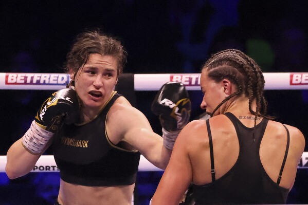 FILE - Ireland's Katie Taylor, left, lands a punch on Britain's Chantelle Cameron during their light-welterweight boxing world title fight at the 3Arena in Dublin, Ireland, Saturday, May 20, 2023. Undisputed lightweight champion Katie Taylor questioned whether women's boxing has the “strength and depth” to move to 3-minute rounds. The Irish fighter will try to avenge the only loss of her professional career when she faces Chantelle Cameron this month in a rematch of their fight in May. (AP Photo/Peter Morrison, File)