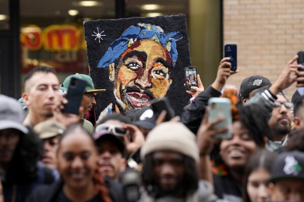 FILE - An image of Tupac Shakur appears among fans during a ceremony honoring Shakur with a star on the Hollywood Walk of Fame on June 7, 2023, in Los Angeles. Duane “Keffe D” Davis charged with killing Tupac Shakur in 1996 will have a lawyer from one of Las Vegas’ best-known political families with him when he appears in court Thursday, Oct. 19, on a murder charge. Ross Goodman said Wednesday, Oct. 18, he'll appear with Davis but will seek two more weeks to confirm as his attorney. (AP Photo/Chris Pizzello, File)
