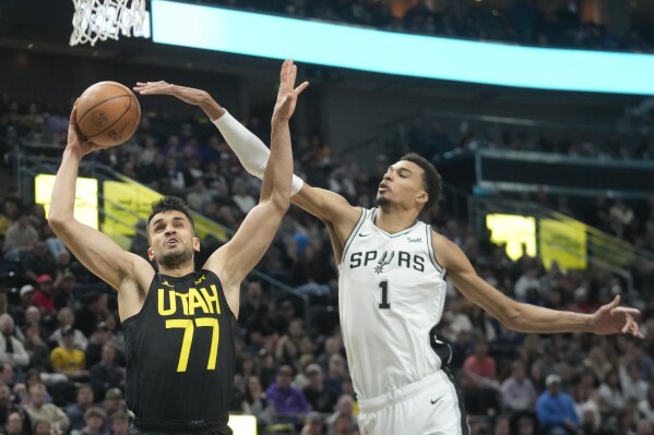 San Antonio Spurs center Victor Wembanyama (1) defends against Utah Jazz center Omer Yurtseven (77) during the first half of an NBA basketball game Wednesday, March 27, 2024, in Salt Lake City. (AP Photo/Rick Bowmer)