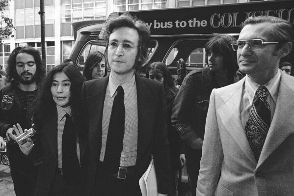 FILE - From left, Yoko Ono, former Beatle John Lennon and attorney Leon Wildes leave the Immigration and Naturalization Service, at 20 West Broadway, March 16, 1972, in New York. Wildes, a prominent immigration lawyer best known for his landmark, yearslong fight in the 1970s to prevent John Lennon from being deported and enable the former Beatle to receive permanent residency in the U.S., died Monday, Jan. 8, 2024, at Lenox Hill Hospital in New York. He was 90. (AP Photo/Anthony Camerano, File)