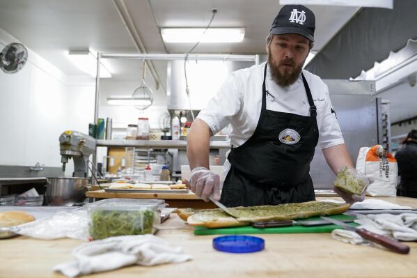 Chef Josh Gjersand prepares a sandwich for Mount Diablo High School students to try during a taste test in Concord, Calif., Friday, Jan. 13, 2023. The school district in suburban San Francisco has been part of a national "farm-to-school" movement for years, where schools try to buy as much locally as possible. But the mission has been kicked into higher gear with a California program that provides free meals to all public school students in the state, along with unprecedented new funding. (AP Photo/Godofredo A. Vásquez)
