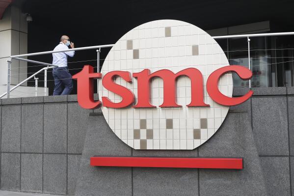 FILE - A person walks into the Taiwan Semiconductor Manufacturing Co., Ltd. (TSMC) headquarters in Hsinchu, Taiwan, on Oct. 20, 2021. Taiwan Semiconductor Manufacturing Co., the biggest contract manufacturer of processor chips, reported Thursday, Jan. 13, 2022, its quarterly profit rose 16.4% over a year earlier to $6 billion amid surging demand for chips for smartphones and other electronics.(AP Photo/Chiang Ying-ying, File)