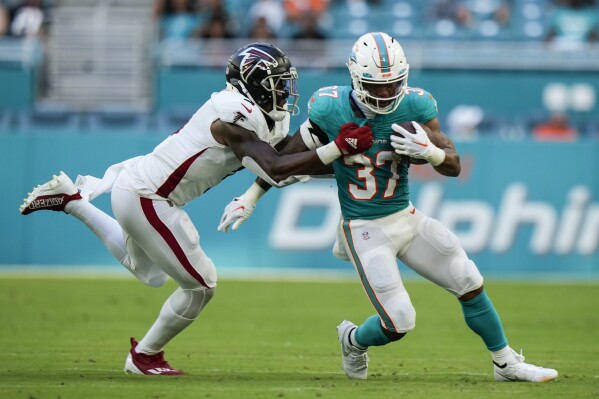 Miami Dolphins running back Myles Gaskin (37) is stopped by Atlanta Falcons linebacker Mykal Walker (3) during the first half of a preseason NFL football game, Friday, Aug. 11, 2023, in Miami Gardens, Fla. (AP Photo/Wilfredo Lee)