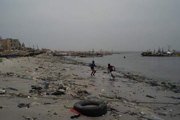 FILE - Boys play soccer among trash that litters the sand of Yarakh Beach in Dakar, Senegal, Nov. 8, 2022. Reducing waste while boosting recycling and reuse, known as the ‘circular economy,’ will be vital for halting the loss of nature, organizers of the World Circular Economy Forum said Wednesday, Dec. 7. (AP Photo/Leo Correa, File)