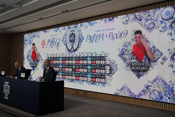 A picture of Portugal's Cristiano Ronaldo is displayed on the video screen while soccer coach Roberto Martinez announces the squad for the Euro 2024 at the federation headquarters in Oeiras, outside Lisbon, Tuesday, May 21, 2024. (AP Photo/Armando Franca)