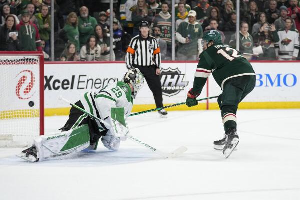 Minnesota Wild left wing Matt Boldy (12), right, shoots and scores a goal past Dallas Stars goaltender Jake Oettinger (29) during a penalty shoot-out of an NHL hockey game Friday, Feb. 17, 2023, in St. Paul, Minn. (AP Photo/Abbie Parr)