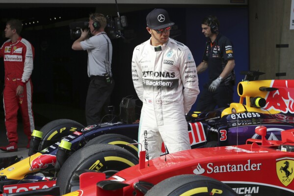 FILE - Mercedes driver Lewis Hamilton of Britain looks at Finnish driver Kimi Raikkonen's Ferrari after getting pole in the qualifying session for the Chinese Formula One Grand Prix at Shanghai International Circuit in Shanghai, China, Saturday, April 11, 2015. Seven-time Formula One champion Lewis Hamilton has been linked with a shock move from Mercedes to Ferrari next year. (AP Photo/Toru Takahashi, File)