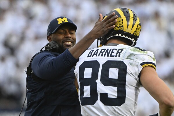 Michigan acting head coach Sherrone Moore celebrates a touchdown with tight end AJ Barner (89) during an NCAA college football game against Penn State, Saturday, Nov. 11, 2023, in State College, Pa. (AP Photo/Barry Reeger)