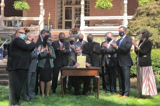 FILE - North Carolina Gov. Roy Cooper completes signing into law a major energy bill as several legislators and an aide applaud during an Executive Mansion ceremony in Raleigh, N.C, Oct. 13, 2021. Duke Energy Corp.'s electricity-generating subsidiaries for North Carolina told regulators on Monday, May 16,2022, how they can comply with a new state law demanding significant greenhouse gas reductions by the end of the decade. (AP Photo/Gary D. Robertson, File)