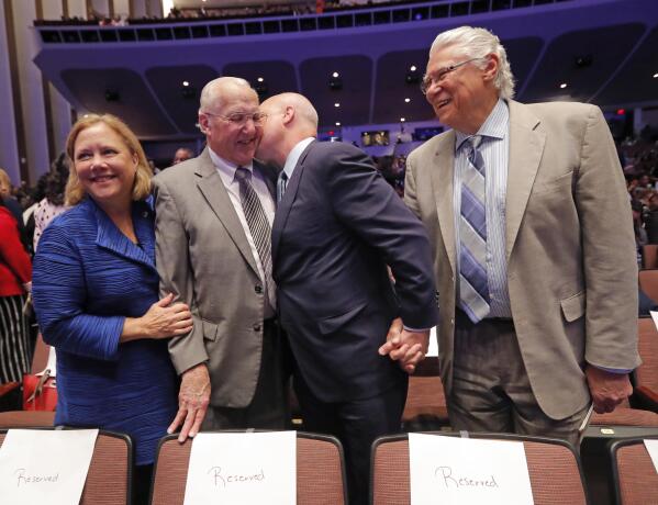 FILE - Outgoing New Orleans Mayor Mitch Landrieu kisses his father, former New Orleans Mayor Moon Landrieu, before they pose for a photo with his sister, former Sen. Mary Landrieu, D-La., and former New Orleans Mayor Sidney Barthelemy, right, before the inauguration of newly elected New Orleans Mayor Latoya Cantrell in New Orleans, Monday, May 7, 2018. Moon Landrieu, the patriarch of a Louisiana political family who was a lonely voice for civil rights until the tide turned in the 1960s, has died at age 92. A family friend said Landrieu died Monday, Sept. 5, 2022. (AP Photo/Gerald Herbert, File)