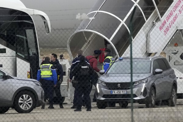 Men board the plane grounded by police at the Vatry airport , Monday, Dec. 25, 2023 in Vatry, eastern France. (AP Photo/Christophe Ena)