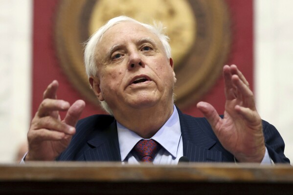 FILE - West Virginia Gov. Jim Justice delivers the State of the State address in Charleston, W.Va., on Wednesday, Jan. 10, 2024. A Virginia bank, that is seeking to recover more than $300 million in longstanding unpaid business loans to the family of West Virginia Gov. Jim Justice, is planning to auction off land at a sporting club located at the governor’s posh resort. (AP Photo/Chris Jackson, File)