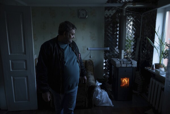 Andriy Gorghinskyy 49, is seen in his parent's house with autonomous heating in the village of Malyutyanka near Kyiv, Ukraine, Tuesday, Oct. 10, 2023. Many Ukrainians are expecting the same or worse this coming winter and have spent months preparing, including collecting firewood and buying generators. (AP Photo/Alex Babenko)