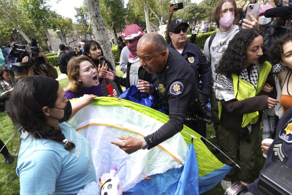 University of Southern California protesters fight with University Public Safety officers as they try to remove tents at the campus' Alumni Park during a pro-Palestinian occupation on Wednesday, April 24, 2024 in Los Angeles. (AP Photo/Richard Vogel)