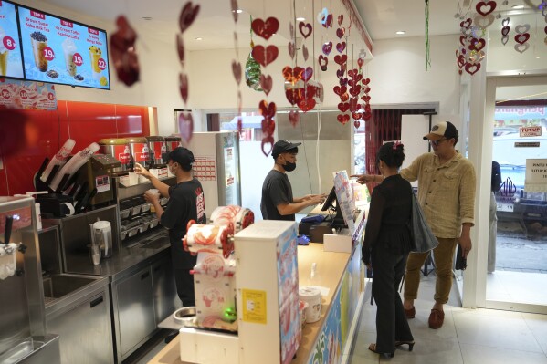 A costumer orders a drink at a Mixue store in Jakarta, Indonesia, Wednesday, Feb. 19, 2025. (AP Photo/Achmad Ibrahim)