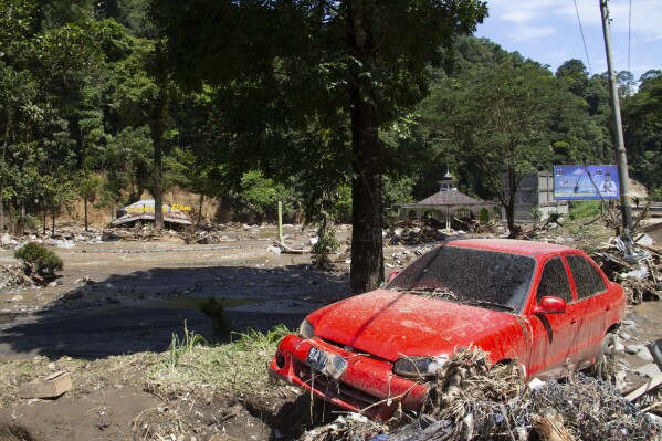 The wreckage of a car lies in a village affected by a flash flood in Tanah Datar, West Sumatra, Indonesia, Sunday, May 12, 2024. Heavy rains and torrents of cold lava and mud flowing down a volcano's slopes on Indonesia's Sumatra island triggered flash floods that killed and injured a number of people, officials said Sunday. (AP Photo/Fachri Hamzah)