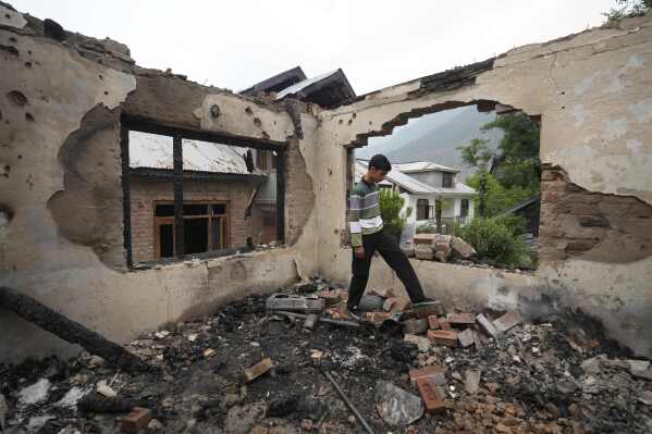 A Kashmiri village boy walks inside a house damaged by Pakistani artillery shelling, at Salamabad village in Uri ,north of Srinagar, Indian controlled Kashmir, Thursday, May 8, 2025. (AP Photo/Mukhtar Khan)