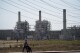 FILE - A man pushes a stroller near the AES power plant in Redondo Beach, Calif., Sept. 7, 2022. The California Energy Commission voted Wednesday, Aug. 9, 2023, to extend the life of three gas power plants along the state's southern coast through 2026, postponing a shutoff deadline previously set for the end of this year. The vote would keep the decades-old facilities — Ormond Beach Generating Station, AES Alamitos and AES Huntington Beach — open so they can run during emergencies. (AP Photo/Jae C. Hong, File)