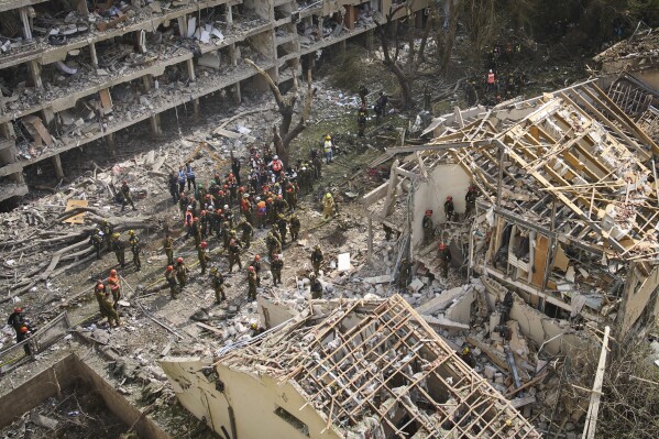 Firefighters, rescue workers and military work at the site of a direct missile strike launched from Iran in Tel Aviv, Israel, on Sunday, June 22, 2025. (AP Photo/Oded Balilty)