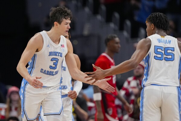 North Carolina guard Cormac Ryan (3) celebrates a three-point shot with teammate North Carolina forward Harrison Ingram (55) during the first half of an NCAA college basketball game against North Carolina State in the championship of the Atlantic Coast Conference tournament, Saturday, March 16, 2024 in Washington. (AP Photo/Alex Brandon)