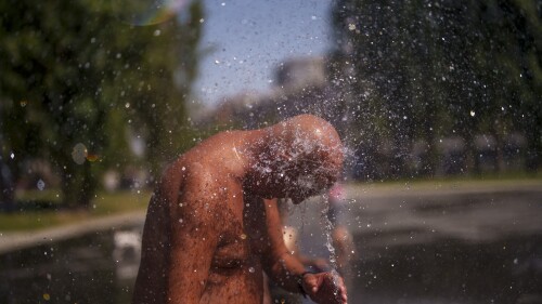 Un hombre se refresca en una playa urbana en el parque Madrid Río, el lunes 26 de junio de 2023, en Madrid. (AP Foto/Manu Fernandez)