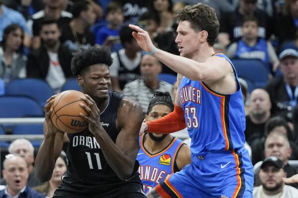 Orlando Magic's Mo Bamba (11) goes to the basket against Oklahoma City Thunder's Mike Muscala (33) during the first half of an NBA basketball game Wednesday, Jan. 4, 2023, in Orlando, Fla. (AP Photo/John Raoux)