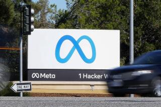FILE - A car passes Facebook's new Meta logo on a sign at the company headquarters on Oct. 28, 2021, in Menlo Park, Calif. Facebook parent Meta is laying off 13% of its employees as it contends with faltering revenue and broader tech industry woes.  (AP Photo/Tony Avelar, File)