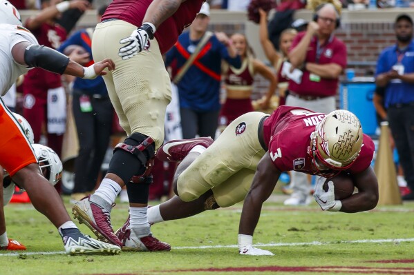 Florida State's Jordan Travis (3) tumbles into the end zone for the first touchdown during the first half NCAA college football game action against Miami, Saturday, Nov. 11, 2023, in Tallahassee, Fla. (AP Photo/Colin Hackley)