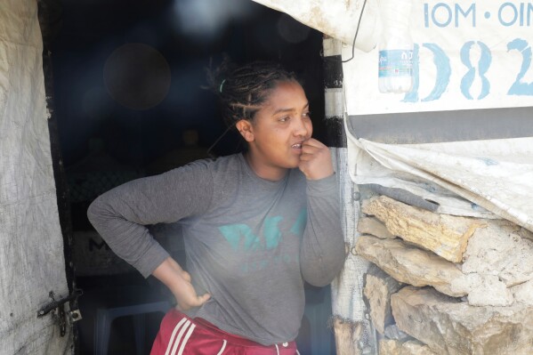 An internally displace woman stands outside her makeshift home in the Sebacare camp, on the outskirts of Mekele, Tigray region, Ethiopia, Wednesday, Feb. 12, 2025. (AP Photo/Alexander Mamo)