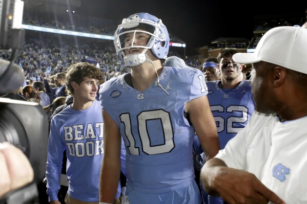 North Carolina quarterback Drake Maye (10) smiles as he heads off the field after North Carolina defeated Duke in two overtimes in an NCAA college football game Saturday, Nov. 11, 2023, in Chapel Hill, N.C. (AP Photo/Chris Seward)