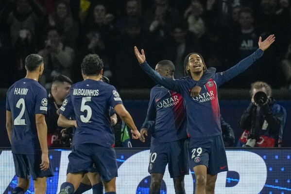 PSG's Bradley Barcola, right, celebrates with teammates after scoring his side's second goal during the Champions League round of 16 first leg soccer match between Paris Saint-Germain and Real Sociedad, at the Parc des Princes stadium in Paris, France, Wednesday, Feb. 14, 2024. (AP Photo/Christophe Ena)