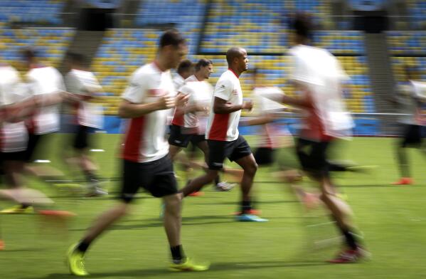 Vincent Kompany, center, of the Belgium soccer team warms up during a training session in Rio de Janeiro, Brazil, Saturday, June 21, 2014. Belgium play in group H of the 2014 soccer World Cup.(AP Photo/Wong Maye-E)