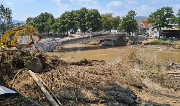Workers use heavy machines to tear down a damaged bridge in the flood-hit town of Ahrweiler, Germany, on Friday, July 23, 2021. With the death toll and economic damage from last week’s floods in Germany continuing to rise, questions have been raised about why systems designed to warn people of the impending disaster didn’t work. (AP Photo/Frank Jordans)