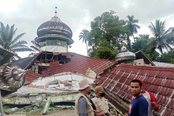 People inspect a damaged mosque following an earthquake in Pasaman, West Sumatra, Indonesia, Friday, Feb. 25, 2022. The strong and shallow earthquake hit off the coast of Indonesia's Sumatra island on Friday, panicking people in Sumatra island and neighboring Malaysia and Singapore. (AP Photo/Marsulai)