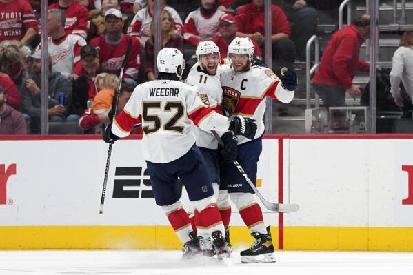 Florida Panthers center Aleksander Barkov (16) celebrates his goal with Jonathan Huberdeau (11) and MacKenzie Weegar (52) in overtime during an NHL hockey game Friday, Oct. 29, 2021, in Detroit. (AP Photo/Paul Sancya)
