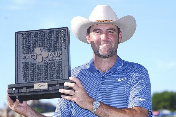 Scottie Scheffler holds the winner's trophy of the CJ Cup Byron Nelson golf tournament in McKinney, Texas, Sunday, May 4, 2025. (AP Photo/LM Otero)