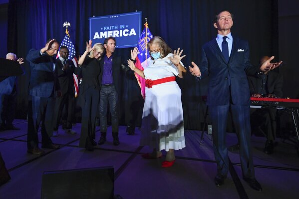 FILE - In this Thursday, July 23, 2020 file photo, from right, Ralph Reed, Dr. Alveda King, Journey keyboardist Jonathan Cain, and personal pastor to the president, Paula White Cain, and others pray on stage during a Donald Trump campaign event courting devout conservatives by combining praise, prayer and patriotism in Alpharetta, Ga.  Like most fellow evangelicals, Reed left room for the president to eke out a victory even as that path appeared slim on Friday, Nov. 6, 2020. But he also singled out Democrats’ lackluster showing in key congressional races as a positive sign and suggested that religious conservatives might see an opportunity to work with a Biden administration that tacks away from the left. (AP Photo/John Amis)