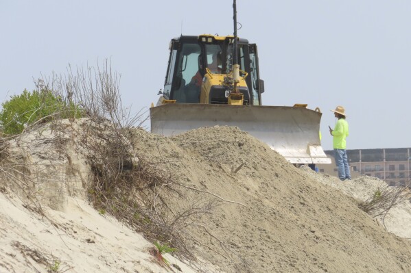 A bulldozer pushes sand along a badly eroded section of beach in North Wildwood N.J. on May 22, 2023. (AP Photo/Wayne Parry)