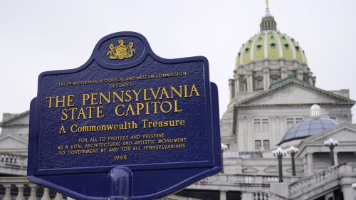FILE - An historical marker at the Pennsylvania Capitol in Harrisburg, Pa., is seen on Feb. 21, 2023. A partisan dispute about funding for three of Pennsylvania’s state-related universities may mean higher tuition for in-state students as a budget impasse continues further into the summer. The state government approached two weeks without full spending authority on Tuesday, July 11, while loose ends remained untied. (AP Photo/Matt Rourke, File)