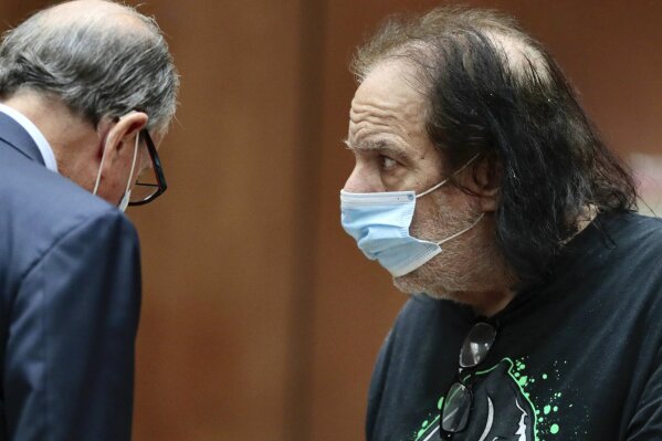 Adult film star Ron Jeremy, right, makes his first appearance in downtown Los Angeles Criminal Court on Tuesday, June 23, 2020. Los Angeles County prosecutors say Jeremy has been charged with raping three women and sexually assaulting a fourth. (Robert Gauthier/Los Angeles Times via AP, Pool)