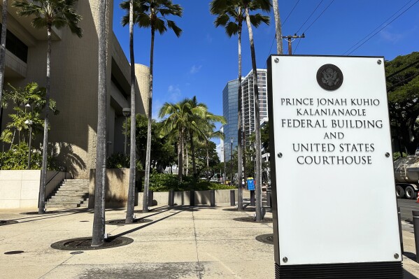 A sign for the Prince Jonah Kuhio Kalanianaole Federal Building and Courthouse is displayed outside the courthouse on Monday, Jan. 22, 2024, in Honolulu. A trial underway at the U.S. courthouse is providing a possible glimpse into Hawaii's underworld. (AP Photo/Jennifer Kelleher)