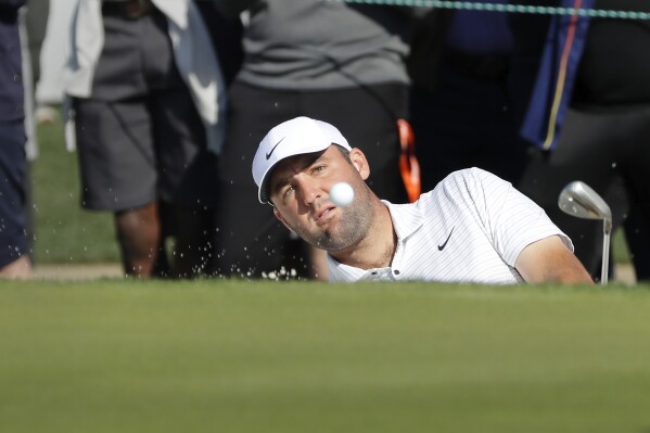 Scottie Scheffler hits out of the bunker on the 18th green during the first round of the Houston Open golf tournament Thursday, March, 28, 2024, in Houston. (AP Photo/Michael Wyke)