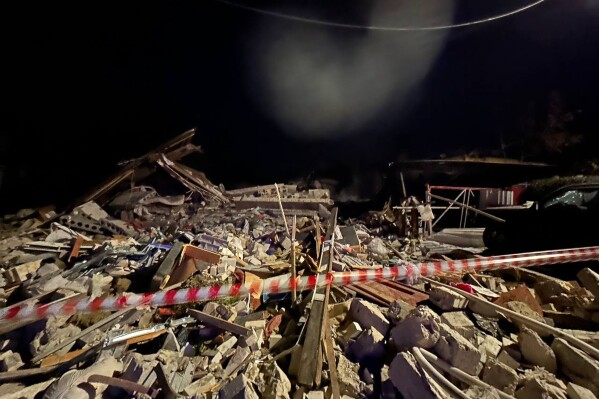 This handout photo released by Belgorod region governor Vyacheslav Gladkov's telegram channel on Thursday, Oct. 12, 2023, shows a damaged house destroyed by debris of a Ukrainian drone that was shot down by Russian air defense outside Belgorod, Russia. Three people, including a child, were killed in Russia's Belgorod region overnight after drone debris fell on a private house, setting it on fire, Belgorod Gov. Vyacheslav Gladkov reported Thursday. Two others have been hospitalized with severe injuries, the official said. (Belgorod region governor Vyacheslav Gladkov telegram channel via AP)